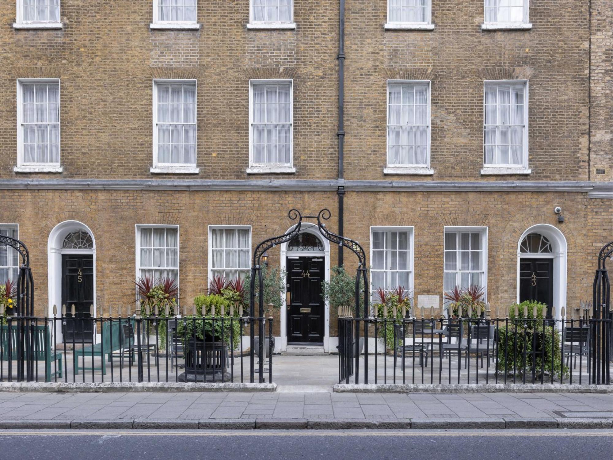 Montcalm Brewery Townhouse Hotel Londra Exterior foto The photo shows a row of three-story brick buildings, featuring a classic design with large windows and decorative ironwork. The buildings are painted in a muted yellow-brown color, typical of older urban architecture. In front of the buildings, ther