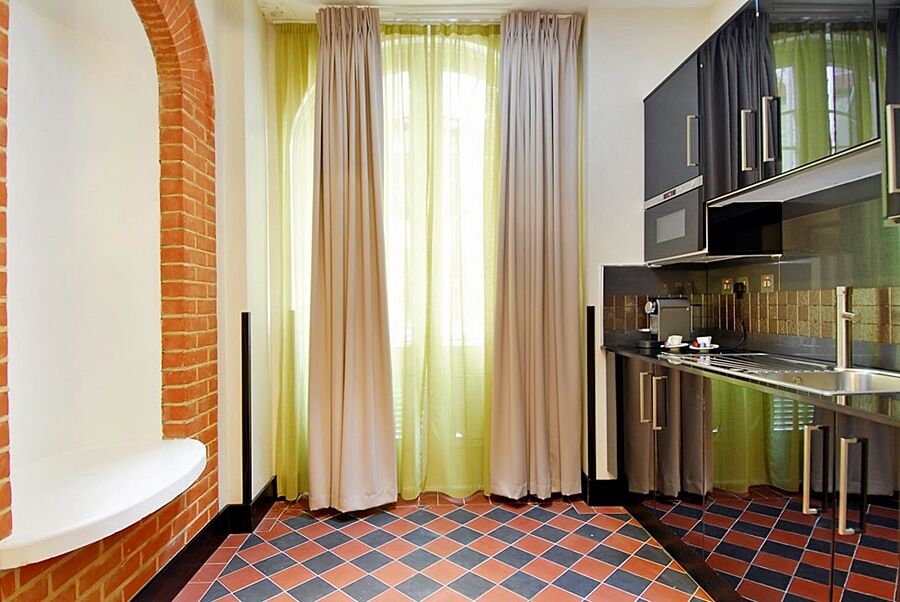 Montcalm Brewery Townhouse Hotel Londra Exterior foto The photo shows a kitchen area with modern design elements. There are large, light-colored curtains hanging from the windows, allowing natural light to filter in. The walls are partially exposed brick, giving a warm texture to the room. The flooring 